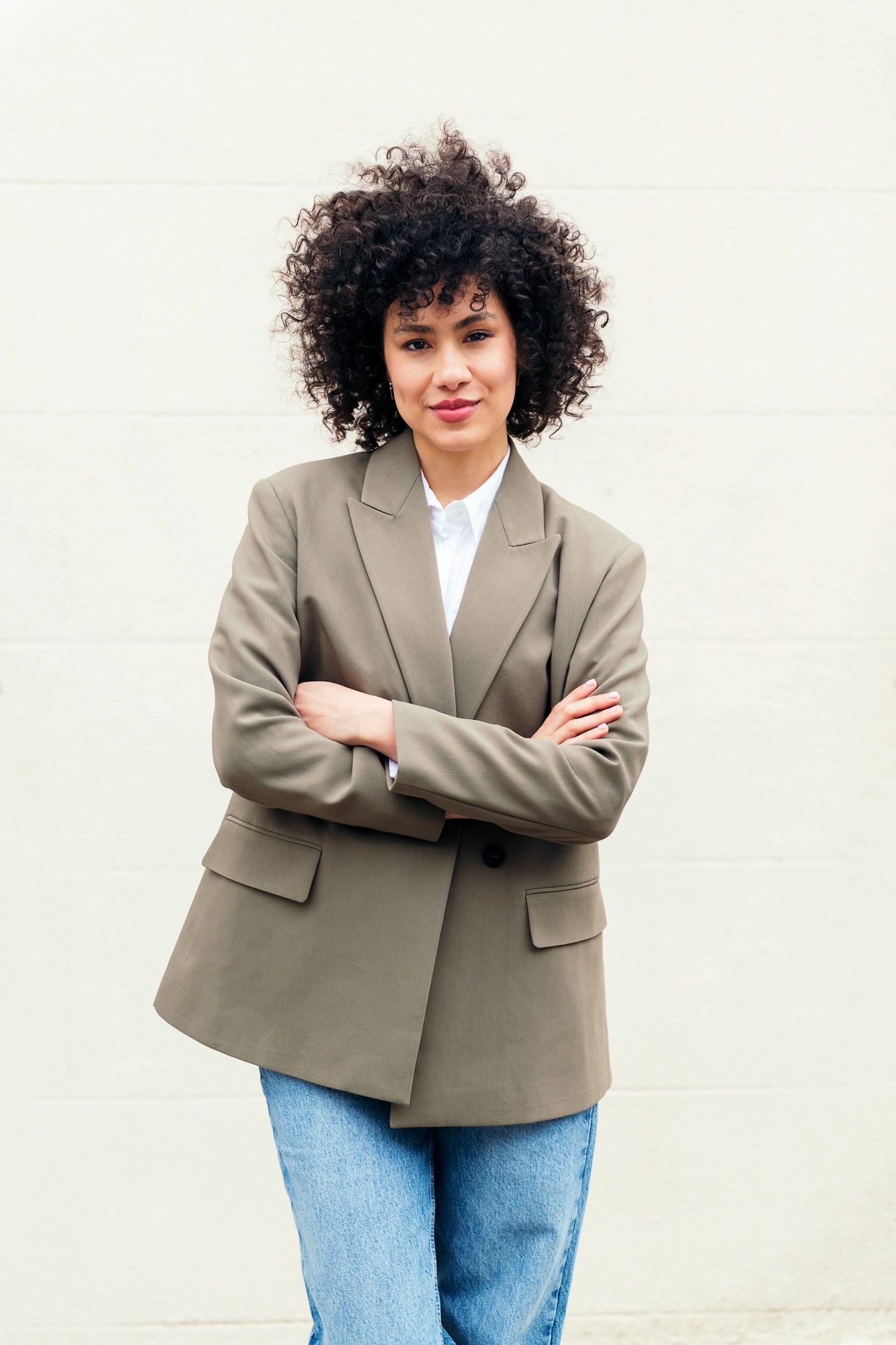 woman with arms crossed smiles looking at camera